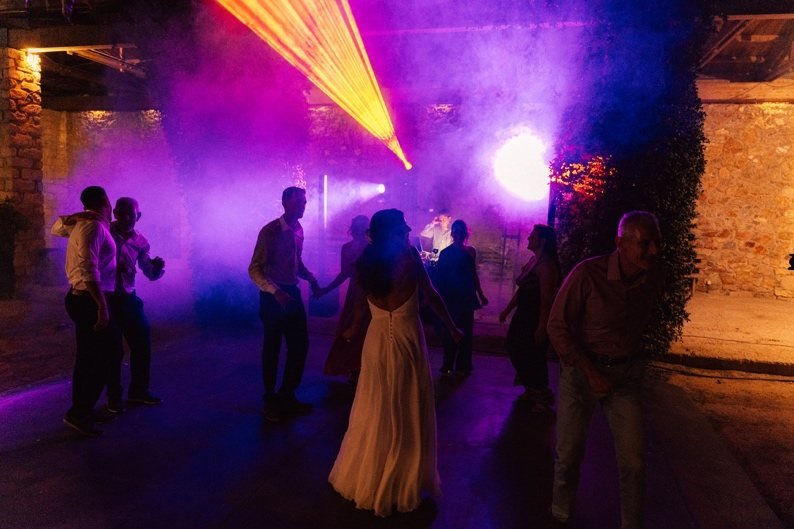 Guests dancing in haze and colored beams
